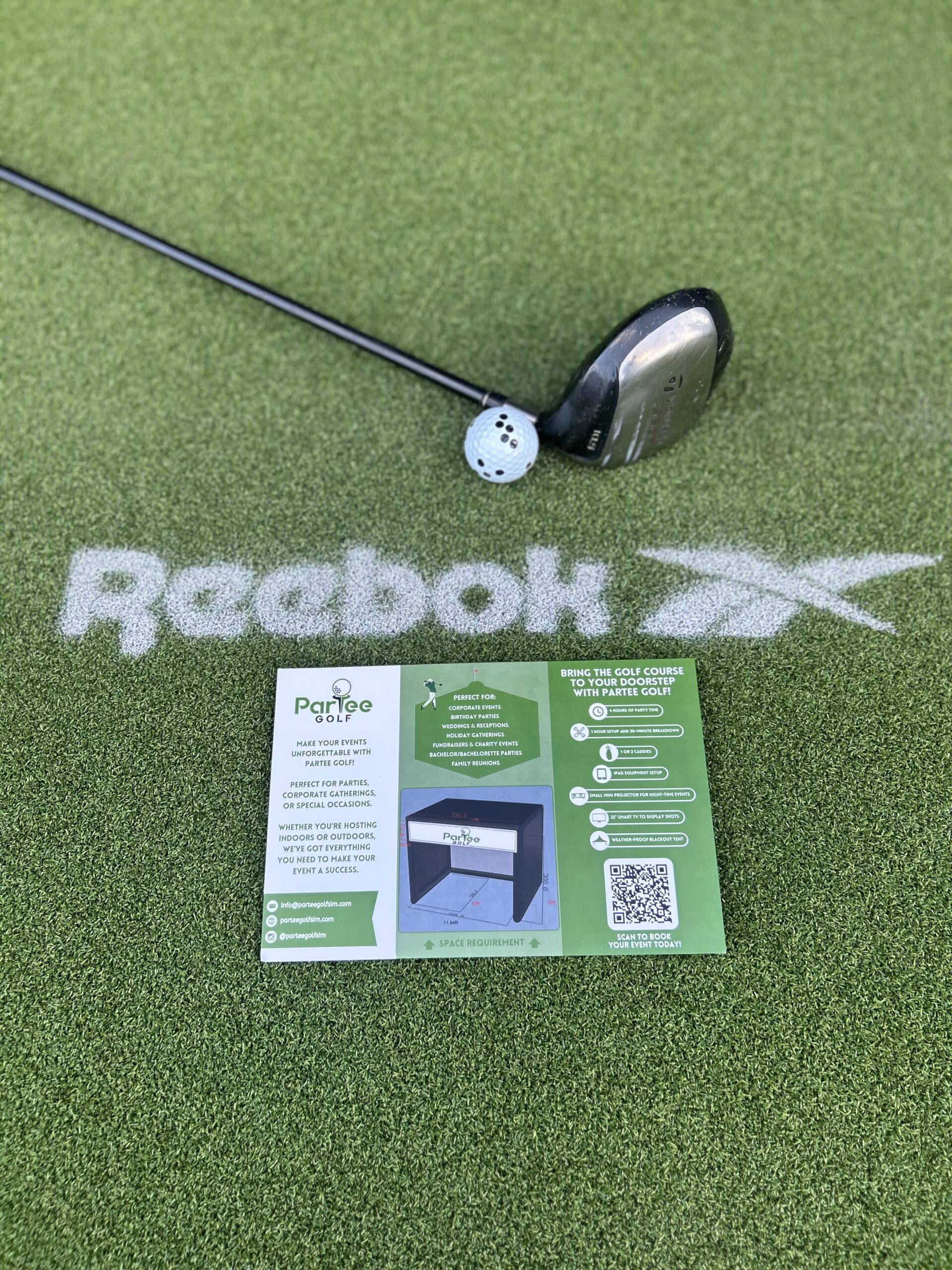 Golf club and ball on artificial turf with ParTee Golf flyer