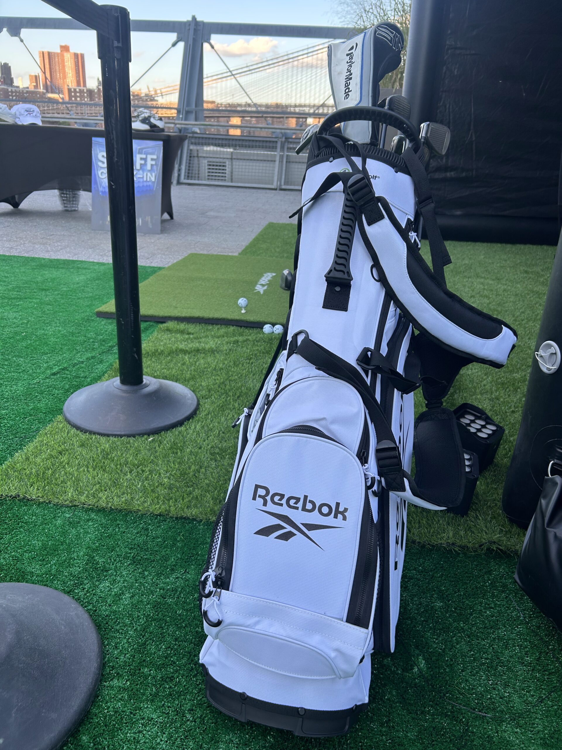 Reebok-branded golf bag on artificial turf at rooftop event